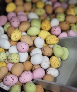 Milk chocolate mini eggs scoop in the plastic free snacks and treats section Just Gaia zero waste grocery in Halifax, West Yorkshire