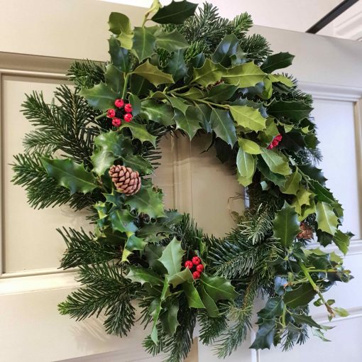 Organic handmade Christmas Wreath as part of our Christmas decorations at Just Gaia Halifax. Shown here hanging from our door.